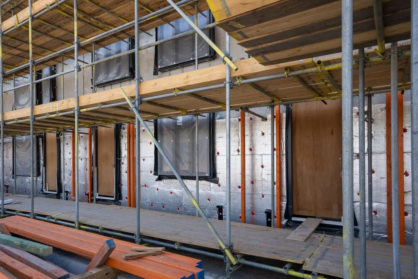 Wohngebäude im Bau mit Gerüst und sichtbaren Dämmplatten